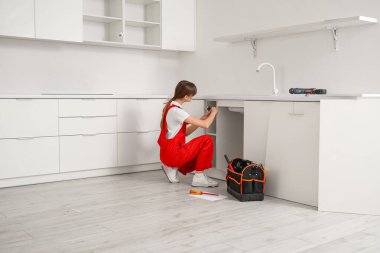 Mutfakta mobilya montajı yapan kadın işçi.