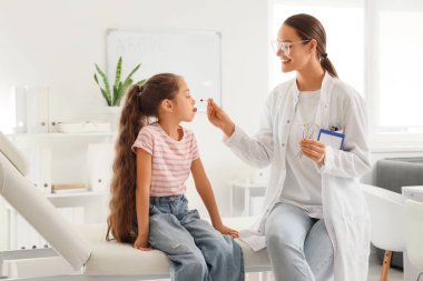 Logopedik sondayla kadın konuşma terapisti ve ofiste küçük bir kız.