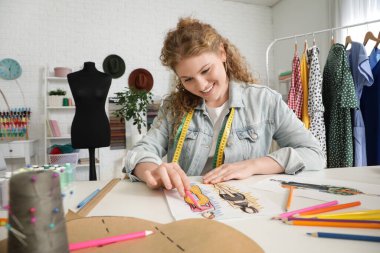 Stüdyoda kadın moda tasarımcısı çizimi