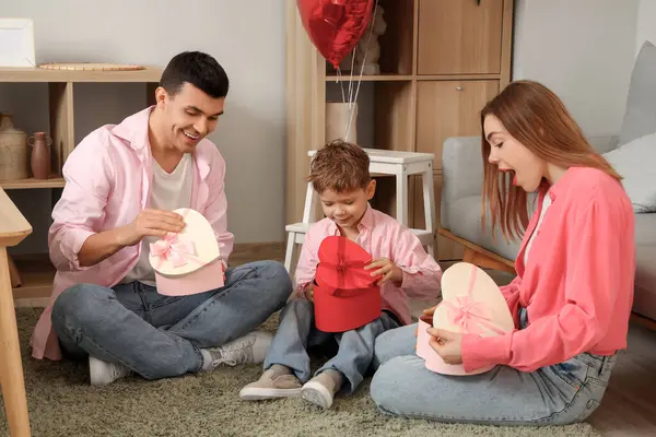 Sevgililer Günü 'nde ailesi ve hediye kutuları olan küçük bir çocuk.