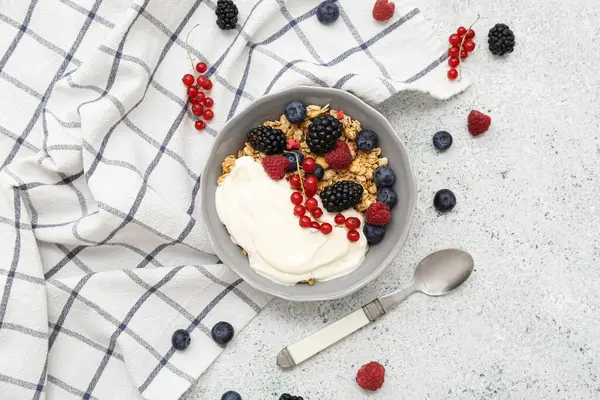 Hafif arkaplanda yoğurt bulunan bir kase lezzetli granola.