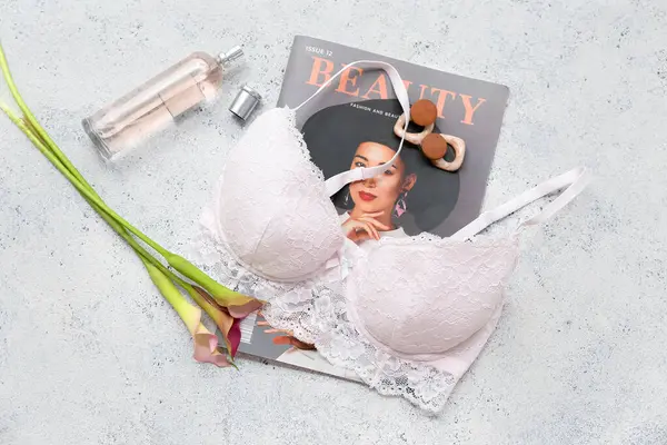 Şık bayan sütyeni, dergisi, parfümü ve çiçekli kompozisyon