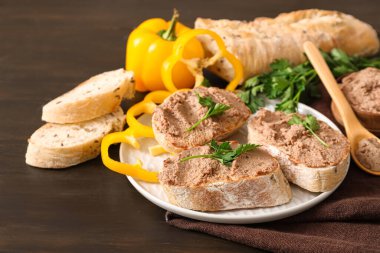 Tost tabağı, lezzetli börek, maydanoz ve koyu ahşap arka planda dolmalık biber dilimleri.