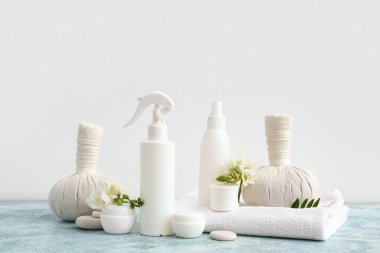 Kozmetik ürünleri, spa aksesuarları ve çiçeklerle renk tablosunda ışık arka planına karşı kompozisyon