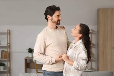 Mutlu evli çift evde sarılıyor.