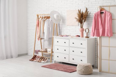 Modern giyinme odasının şık iç mekanı kadın kıyafetleri ve otlarla dolu.