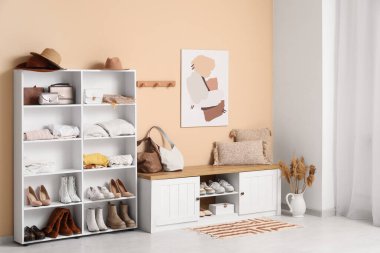 Katlanmış giysiler, ayakkabılar ve aksesuarlarla dolu bir soyunma odası.