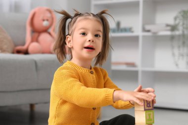 Evinde alfabe öğrenen tahta küpleri olan sevimli küçük bir kız.
