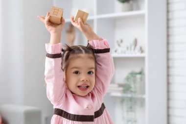 Sevimli küçük kız elinde mektuplarla küpleri tutuyor.