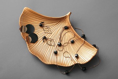 Gri arka planda güzel mücevherleri olan altın tepsi