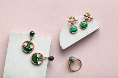 Güzel küpeleri ve gri arkaplanı olan dekoratif podyumlar.