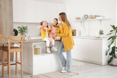 Genç lezbiyen çift ve mutfakta oyuncak tavşanları olan küçük kızları.