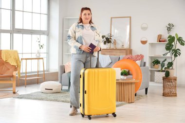 Pasaportu ve bavulu olan genç bir kadın eve gitmek için hazırlanıyor.