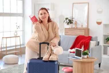 Pasaportu ve bavulu olan genç bir kadın eve gitmek için hazırlanıyor.
