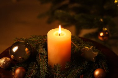 Akşamları yanan mum, köknar dalları ve Noel süsleri olan kompozisyon, yakın plan.