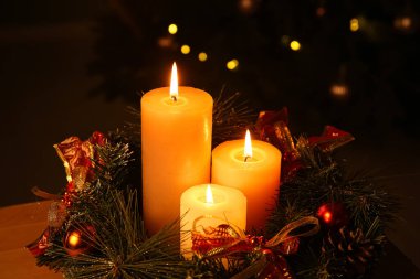 Akşamları yanan mumlar ve Noel çelengi ile süslenmiş köknar ağacına karşı kompozisyon