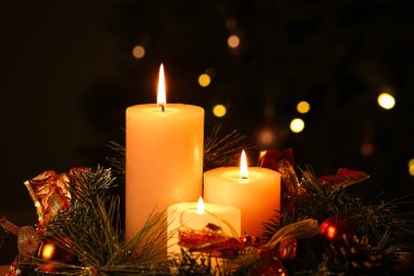 Akşamları yanan mumlar ve Noel çelengi ile süslenmiş köknar ağacına karşı kompozisyon, yakın plan