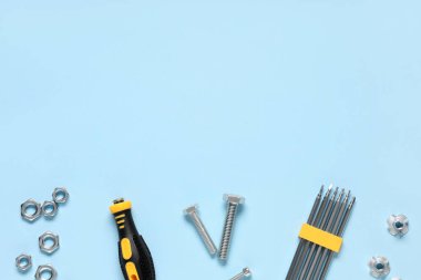 Tap cıvatalar, krom fındıklar ve mavi arkaplanda tornavida parçaları