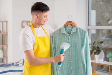 Yakışıklı, genç, mutlu, buharlı gömlekli adam.