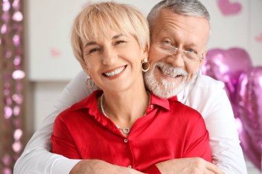 Mutlu, olgun bir çift mutfakta sarılıyor. Sevgililer Günü kutlaması