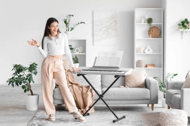 Evde sentezleyicili genç bir kadın