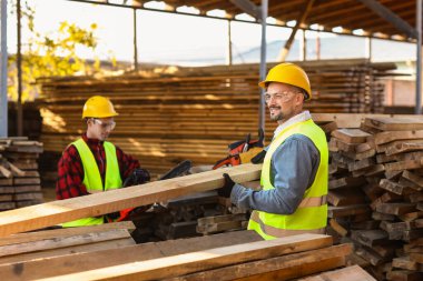 Erkek marangozlar kereste fabrikasında çalışıyor.