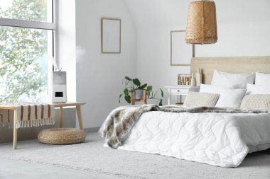 Yatak odasının içinde bitkiler ve bankta hava nemlendirici var.