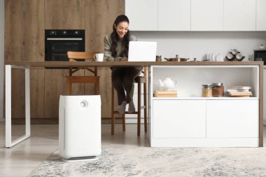 Mutfakta hava temizleyici kullanan genç bir kadın.