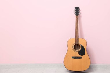 Renkli duvarın yanındaki akustik gitar.