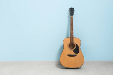 Renkli duvarın yanındaki akustik gitar.