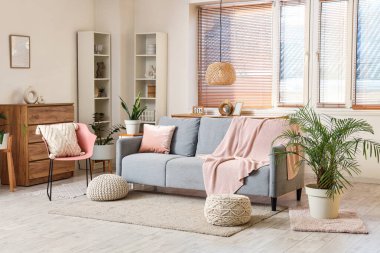 Oturma odasında kanepe, ekose örgü ve sandalye var.