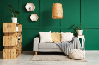 Oturma odası, kanepe, örgü battaniye ve raf ünitesi.