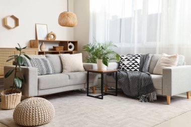 Oturma odasının içinde ekoseli kanepeler ve kahve masası.