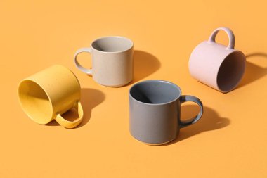 Turuncu arkaplanda seramik bardaklar