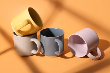 Turuncu arkaplanda seramik bardaklar