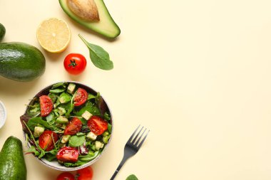 Çeri domatesli avokado salatası ve sarı arka planda limon.