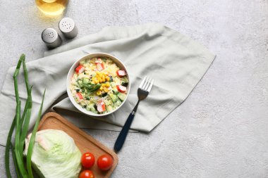 Bir kase salata, yengeç çubuğu, mısır, salatalık ve gri grunge arka planda malzemeler.