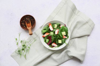 Beyaz grunge arka planda bir kase salata, ıspanak ve salatalık.