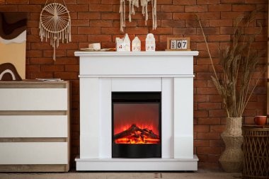 Tuğla duvarın yanında şöminesi ve tuvaleti olan modern bir oturma odası.