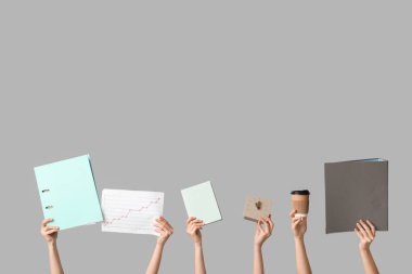 Dosyaları, defteri, kahvesi ve saati gri arka planda olan kadın elleri. Zaman yönetimi kavramı