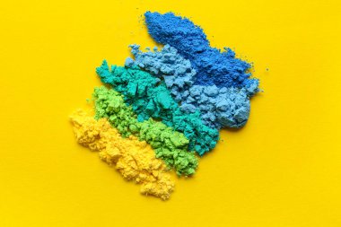 Sarı arkaplanda farklı renk toz pigmentleri kümesi