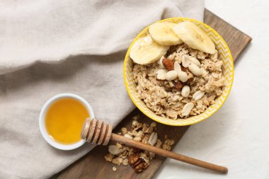 Beyaz arka planda lezzetli yulaf ezmeli, muzlu ve fındıklı kase