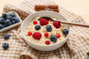 Arka planda lezzetli yulaf ezmesi ve böğürtlenli kase, yakın plan.