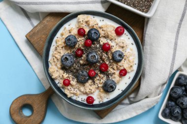 Peçeteli kompozisyon, lezzetli yulaf ezmesi ve mavi arka planda böğürtlen, yakın plan.
