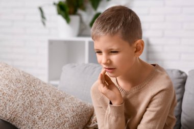 Evde diş ağrısı çeken küçük bir çocuk.