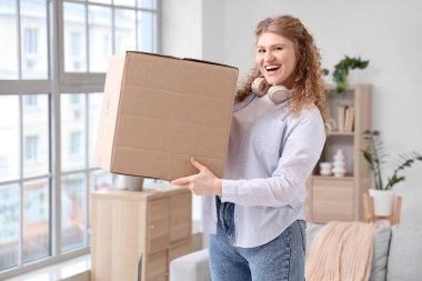 Evde paket kutusu olan genç bir kadın.