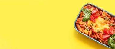 Domates soslu fırında makarna ve sarı zemin üzerinde peynir yazı için yer, üst görünüm