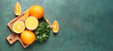 Taze portakal suyu ve yeşil arkaplanda nane aromalı kompozisyon, metin için alan, üst görünüm