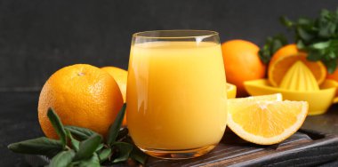 Koyu arkaplanda bir bardak taze portakal suyu, yakın plan.