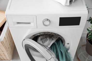 Washing machine with black mold and clothes in laundry room clipart